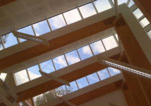 Interior ceiling featuring large wooden beams and rectangular skylights with integrated lighting fixtures; part of Glaze Ltd project.